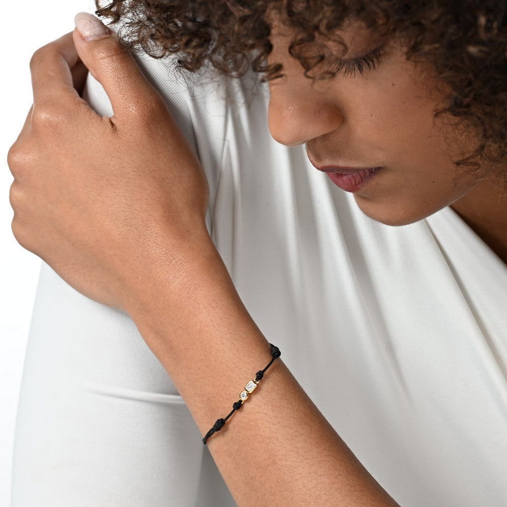 Nahaufnahme von einem schwarzen Cord-Armband mit 2 großen Labordiamanten im Brillant- und Smaragdschliff am Arm getragen.