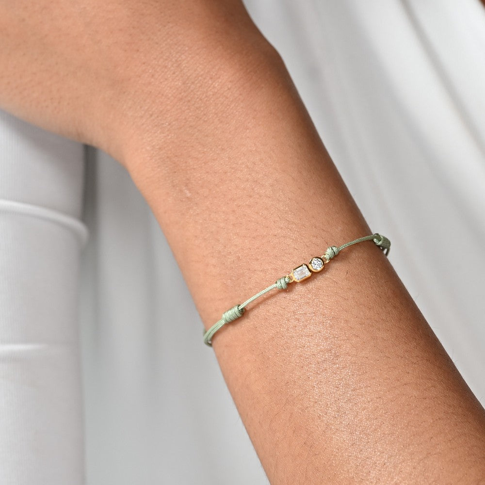 Nahaufnahme von einem grünen Cord-Armband mit 2 großen Labordiamanten im Brillant- und Smaragdschliff am Arm getragen.