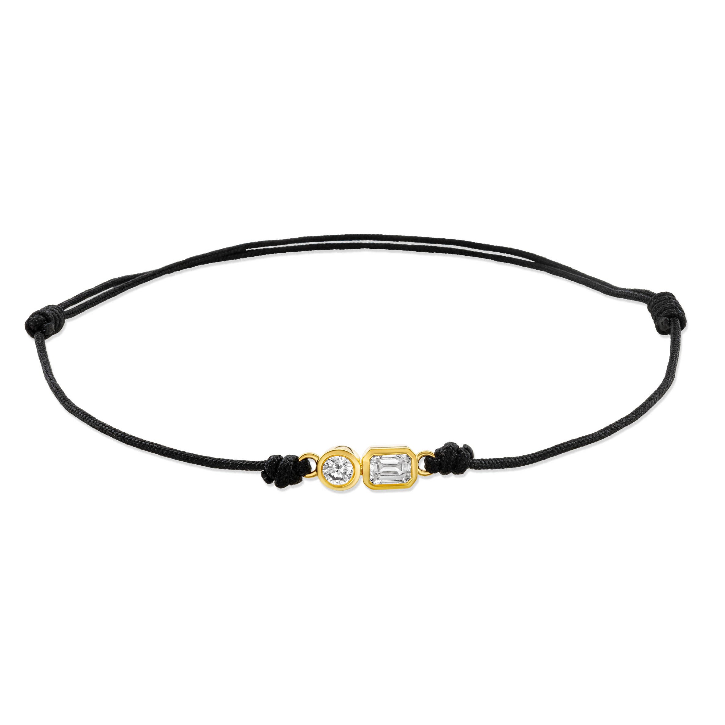 Ein schwarzes Cord-Armband mit 2 Labordiamanten im Brillant- und Smaragdschliff in Zargenfassung auf weißem Hintergrund.