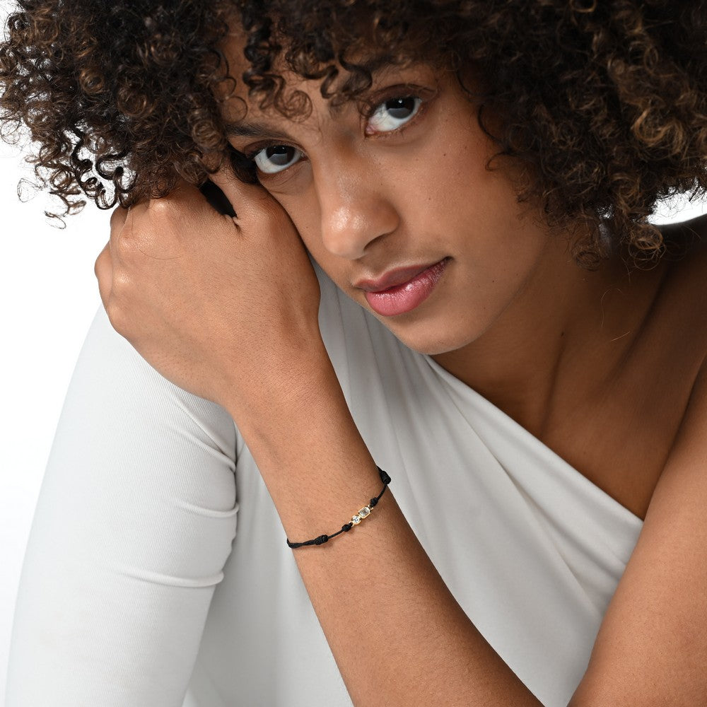 Frau trägt ein schwarzes Cord-Armband mit zwei großen Labordiamanten im Brillant- und Smaragdschliff in Zargenfassung.