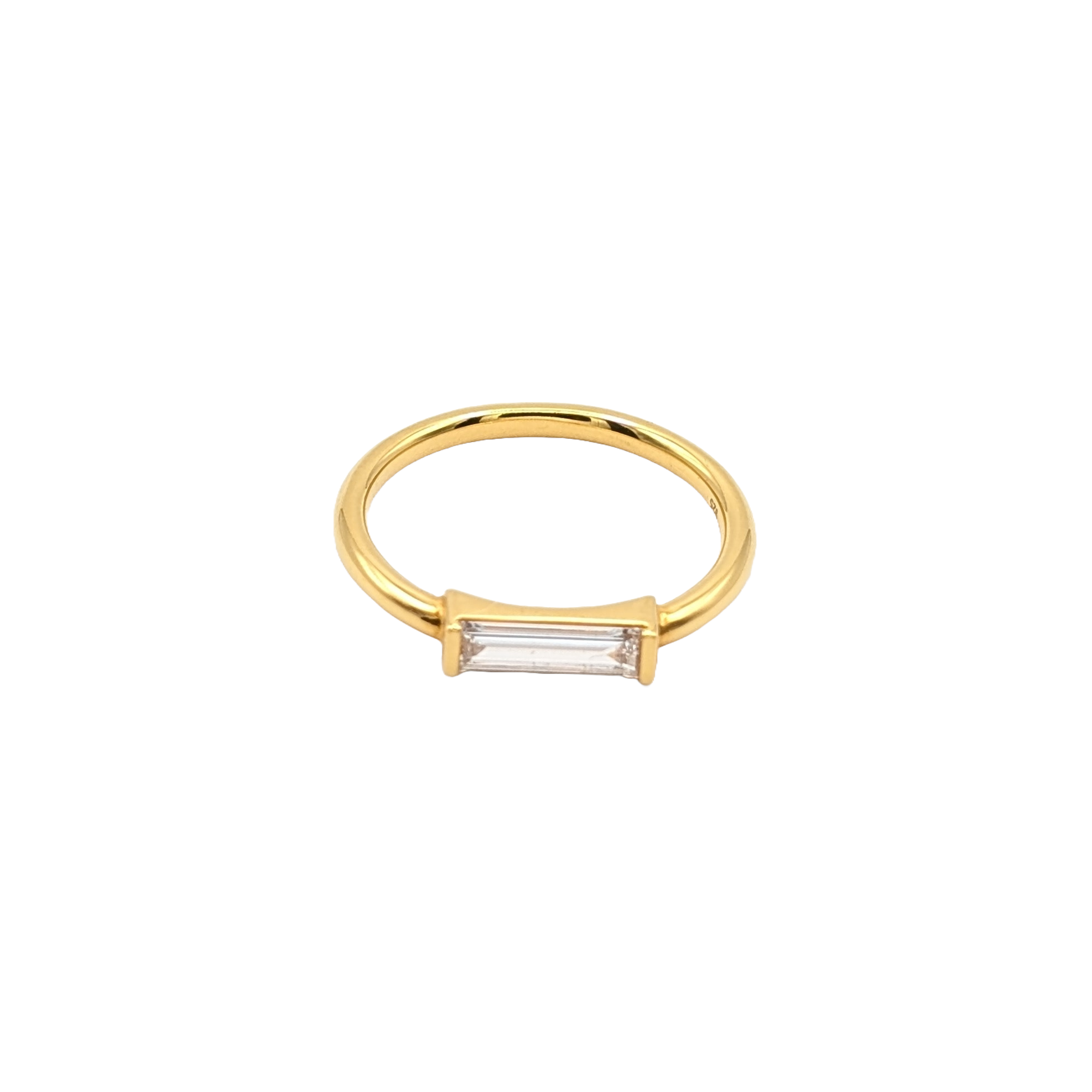 Vergoldeter Ring mit einem länglich geschliffenen Labordiamanten liegt auf weißem Hintergrund.