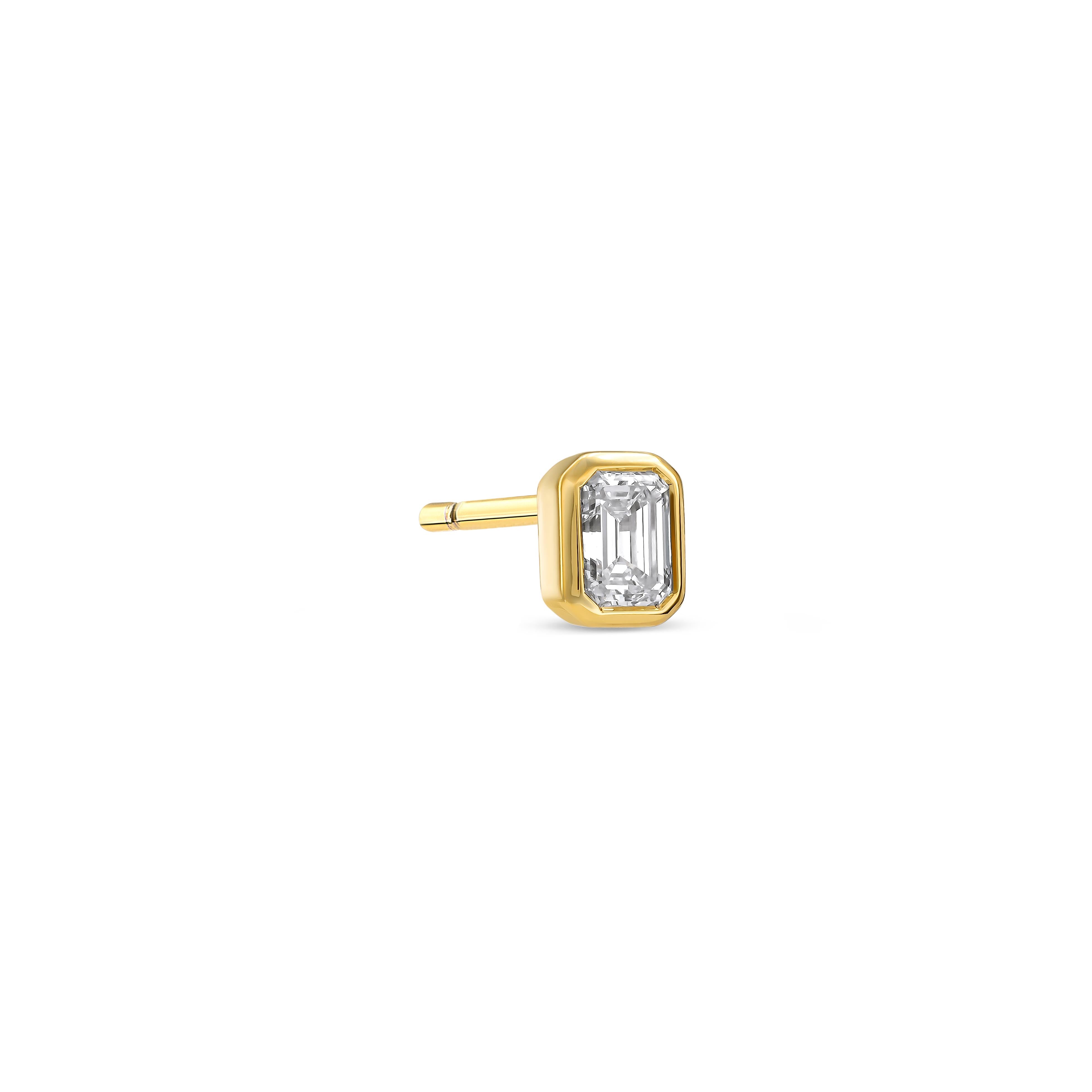 Ein einzelner Diamant-Ohrstecker besetzt mit einem Labordiamanten im Smaragdschliff auf weißem Hintergrund.