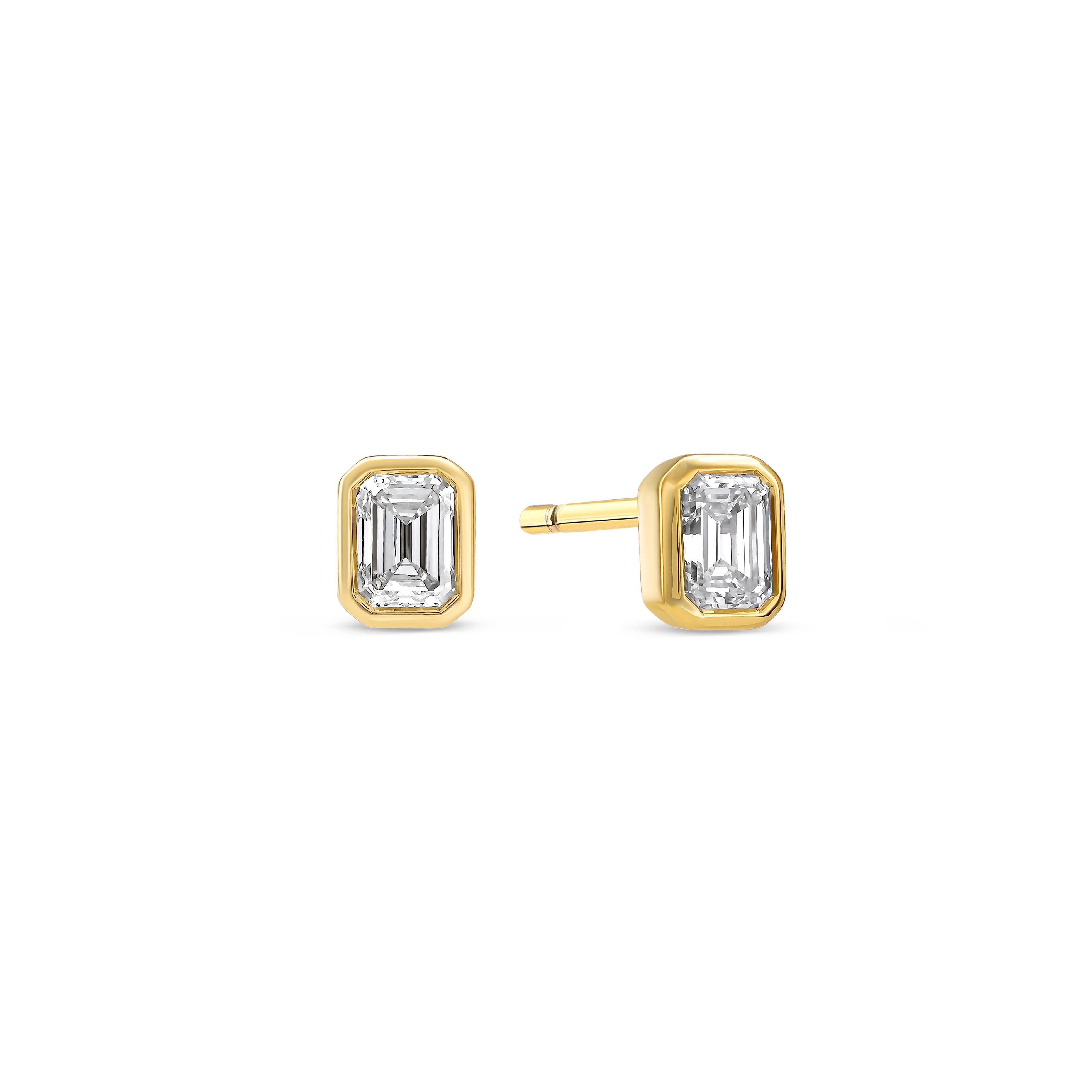 Ein Paar Diamant-Ohrstecker besetzt mit zwei Labordiamanten im Smaragdschliff auf weißem Hintergrund.