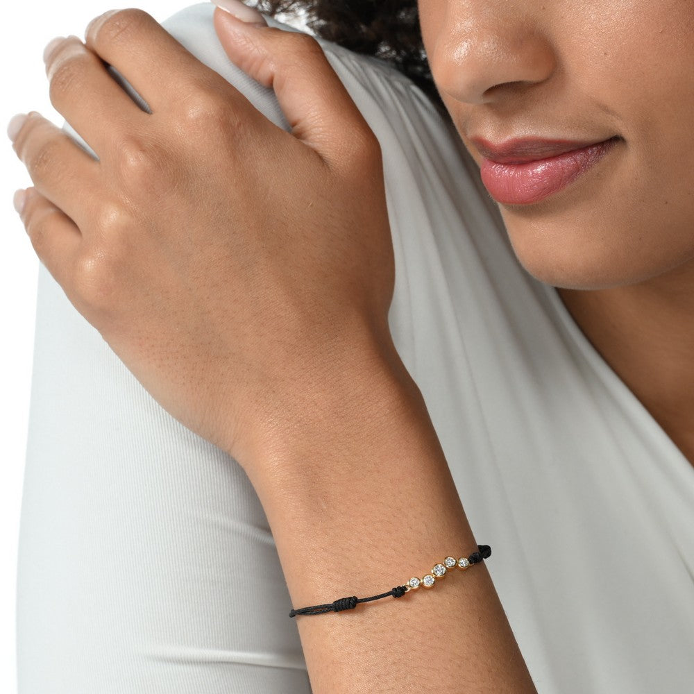 Nahaufnahme von einem schwarzen Cord-Armband mit fünf runden Labordiamanten im Brillantschliff am Arm getragen.