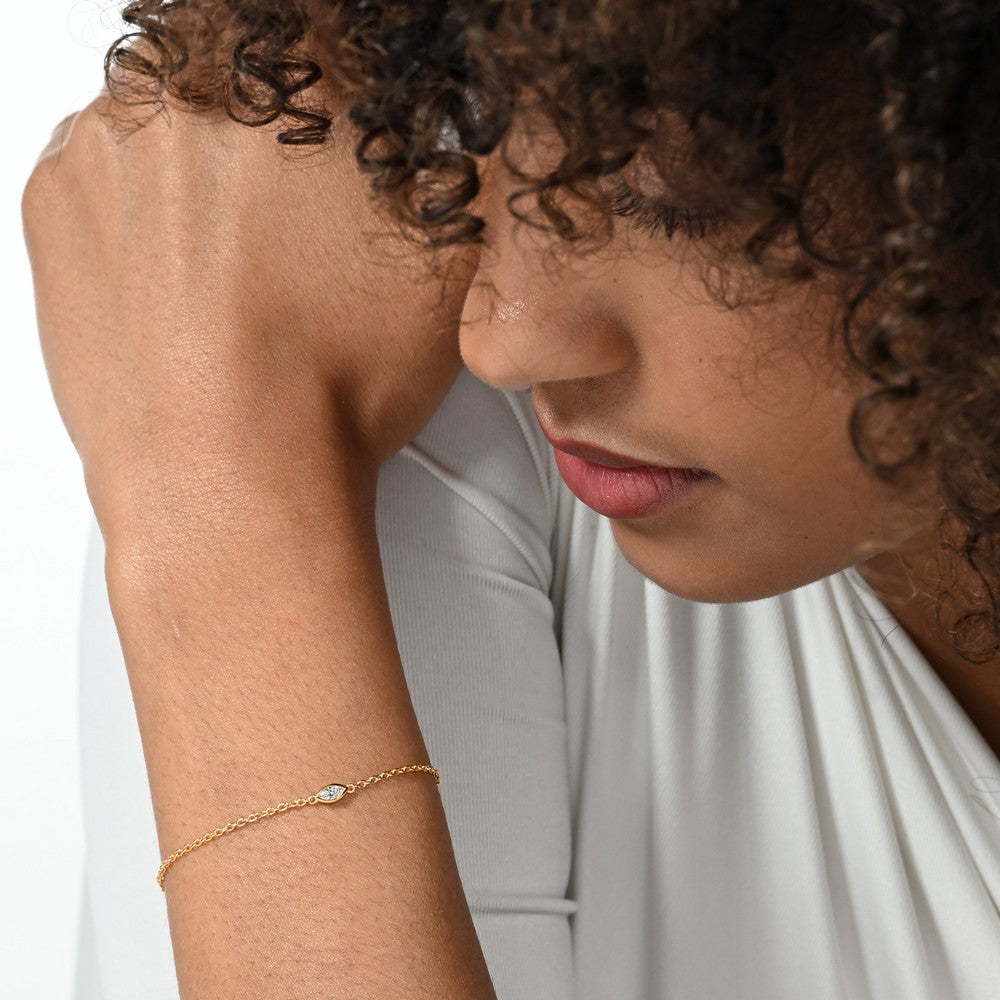 Nahaufnahme von einer vergoldeten Armkette besetzt mit einem einzelnen brillanten Labordiamanten im Marquiseschliff.