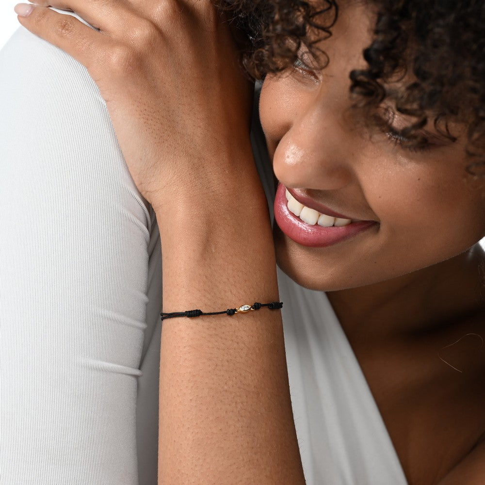 Nahaufnahme von einem schwarzen Cord-Armband mit einem Labordiamanten im Marquiseschliff am Arm getragen.