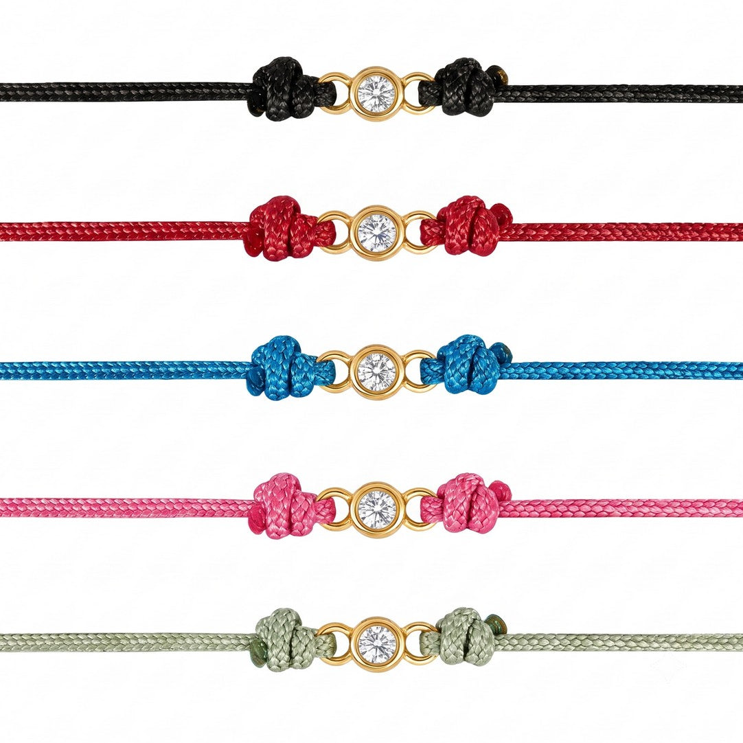 Frontalansicht von 5 bunten Cordarmbändern mit je einem kleinen Labordiamanten in goldfarbener Fassung.