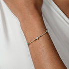 Nahaufnahme von einem grünen Cord-Armband mit einem Labordiamanten im Princessschliff am Arm getragen.