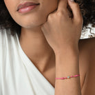 Nahaufnahme von einem pinken Cord-Armband mit einem Labordiamanten im Princessschliff am Arm getragen.