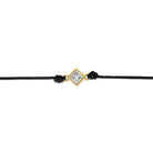 Detailansicht von einem schwarzen Cord-Armband mit einem Labordiamanten im Princessschliff in Zargenfassun.