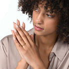 Frau trägt einen vergoldeten Labordiamantring mit zwei Steinen im Carree- und im Marquiseschliff  am Ringfinger.  
