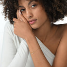 Frau trägt eine vergoldete Armkette mit einem Kite Design mit 11 runden Labordiamanten im Brillantschliff.