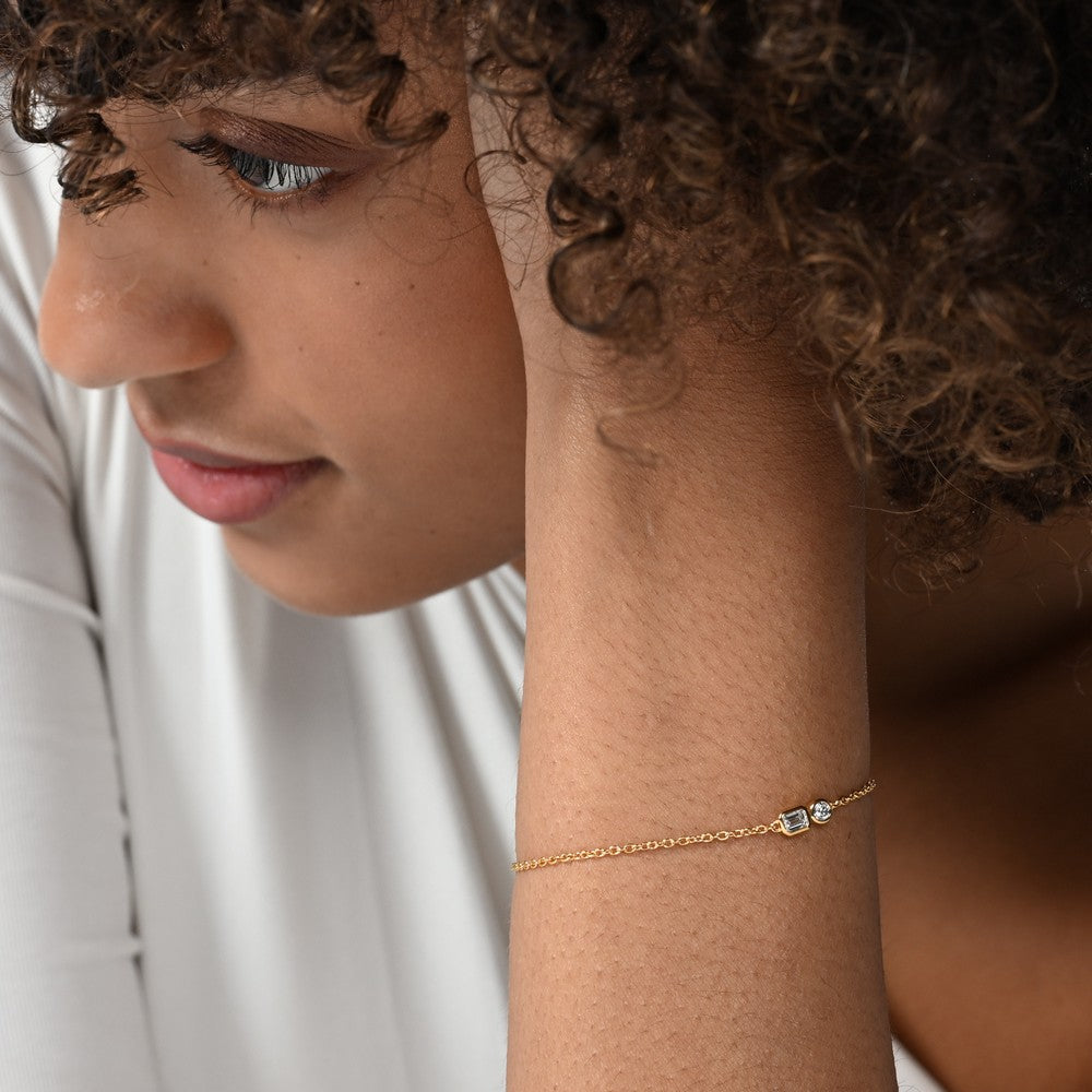 Nahaufnahme von einer vergoldeten Armkette zwei Labordiamanten im Brillantschliff und Smaragdschliff mit total 0,35 carat.