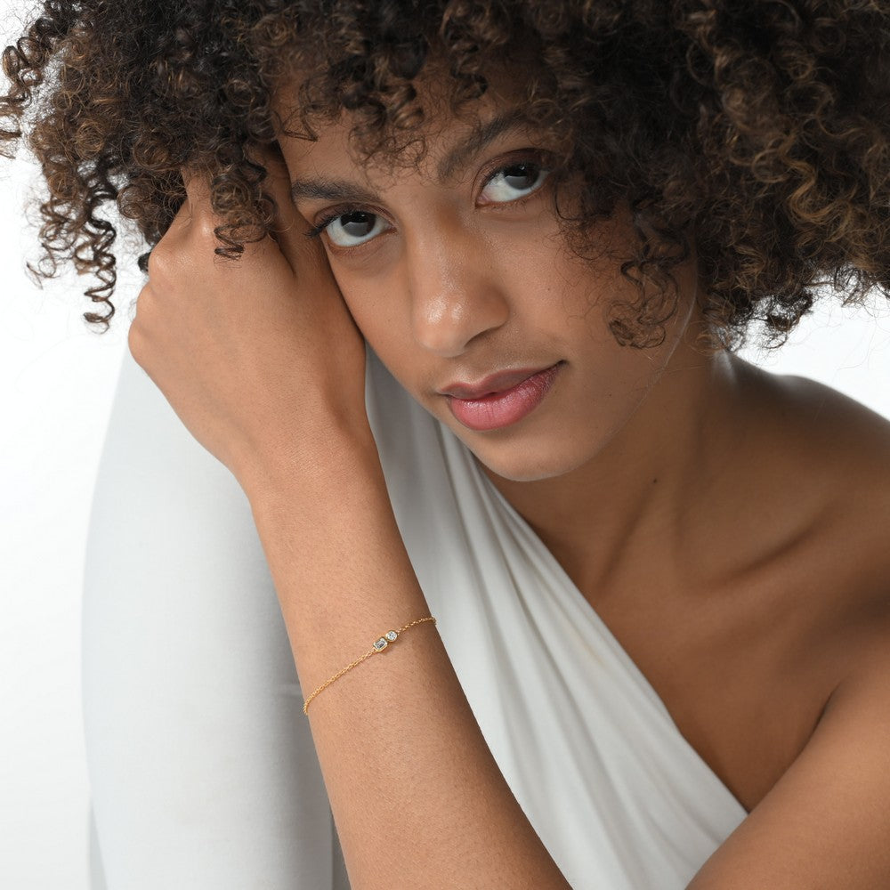 Frau trägt eine vergoldete Armkette besetzt mit zwei Labordiamanten im Brillantschliff und Smaragdschliff mit total 0,35 ct.