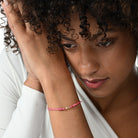 Nahaufnahme von einem pinken Cord-Armband mit 2 Labordiamanten im Brillant- und Smaragdschliff am Arm getragen.