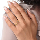 Nahaufnahme von einem vergoldeten Ring mit zwei Labordiamanten im Smaragd- und im Brilliantschliff am Ringfinger getragen.