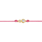 Detailansicht von einem pinken Cord-Armband mit zwei Labordiamanten im Brillantschliff in Zargenfassung.