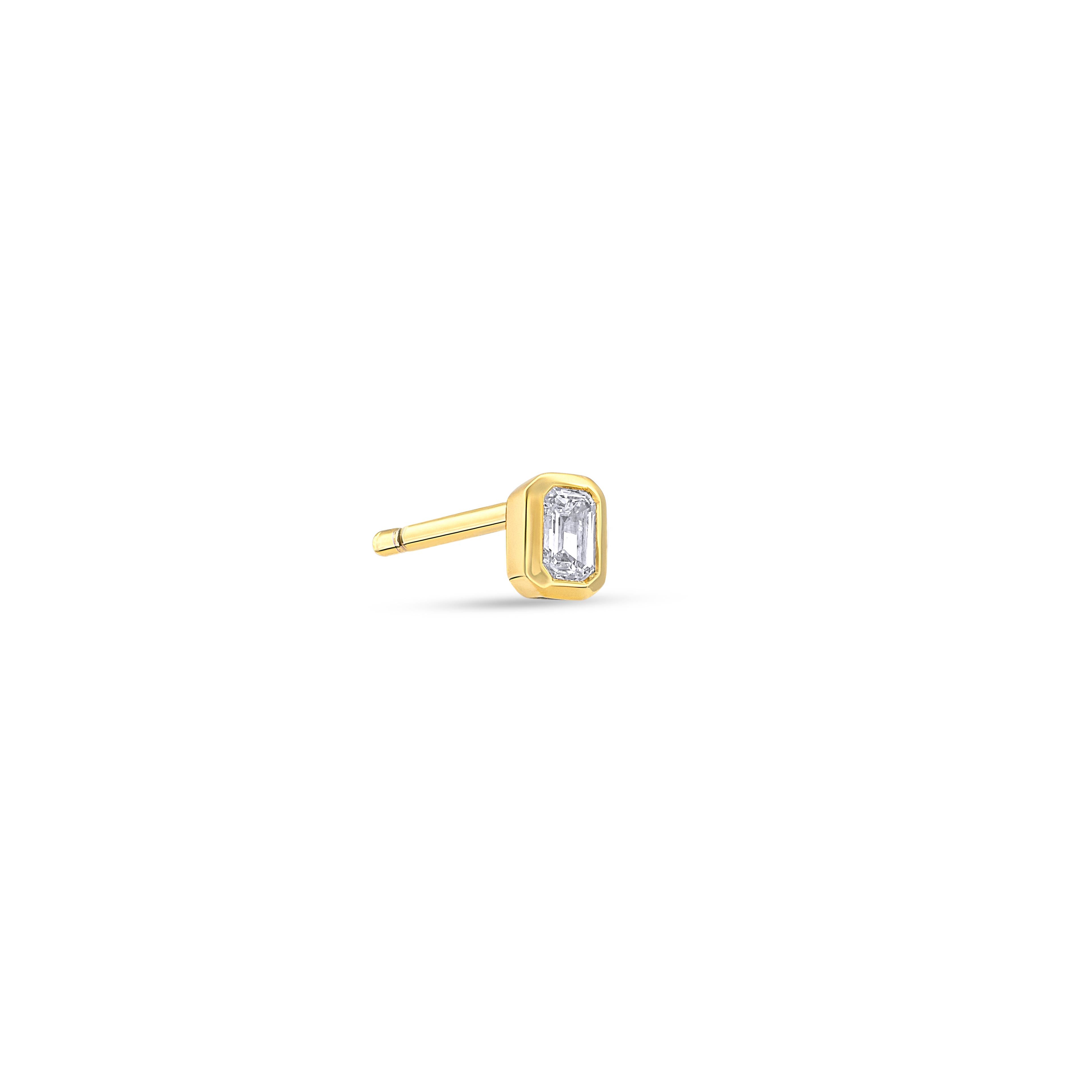 Ein einzelner Diamant-Ohrstecker besetzt mit einem kleinen Labordiamanten im Smaragdschliff auf weißem Hintergrund.