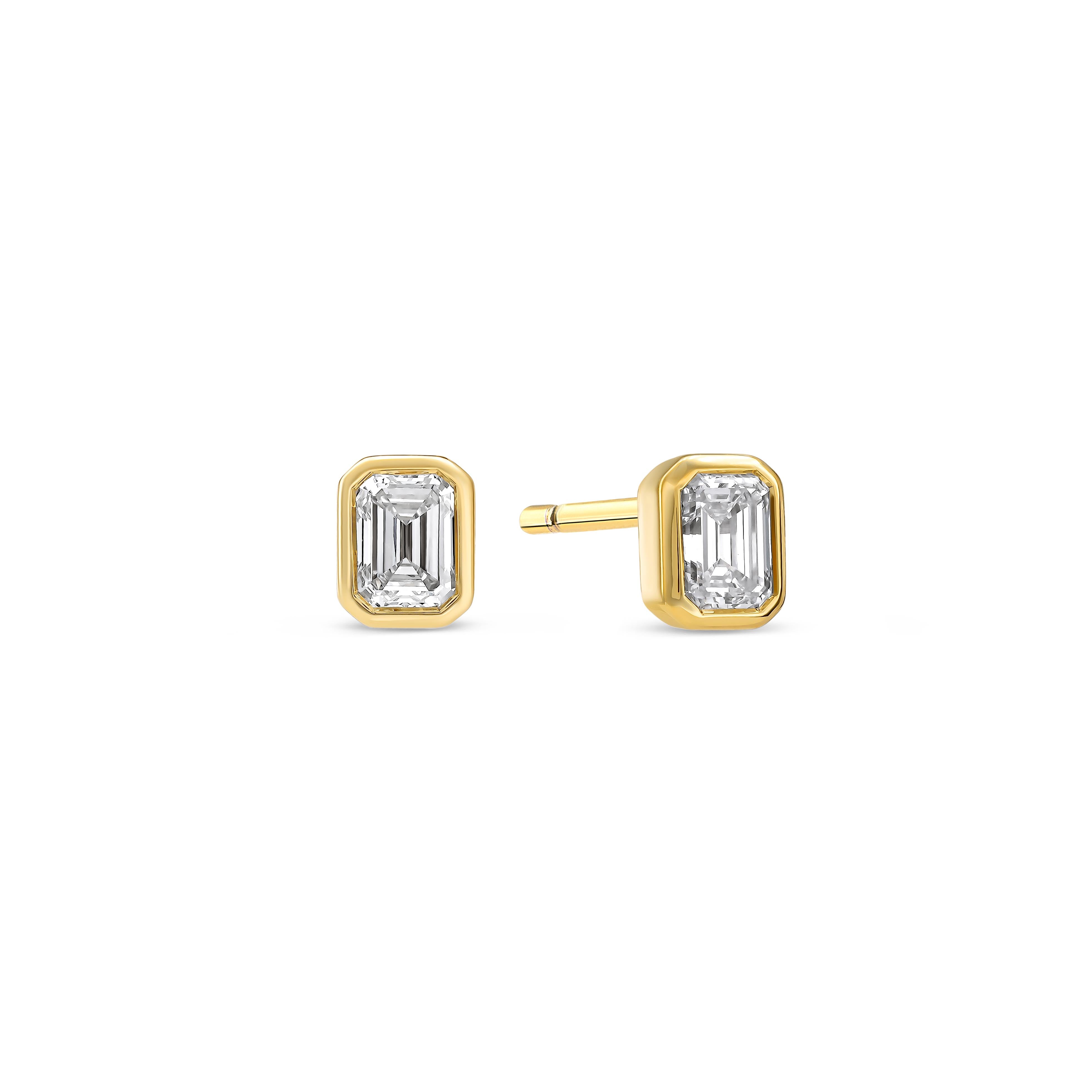 Ein Paar Diamant-Ohrstecker besetzt mit zwei Labordiamanten im Smaragdschliff auf weißem Hintergrund.