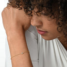 Nahaufnahme von einer vergoldeten Armkette besetzt mit einem einzelnen brillanten Labordiamanten im Marquiseschliff.