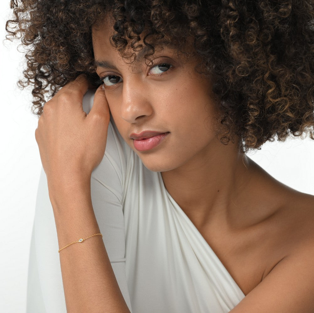 Frau trägt eine vergoldete Armkette mit einem einzelnen brillanten Labordiamanten im Marquiseschliff.