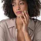 Frau trägt einen einen vergoldeten Ring im offenen Design mit zwei runden Labordiamanten im Brillantschliff  am Ringfinger.  