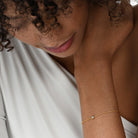 Nahaufnahme von einer vergoldeten Armkette besetzt mit einem einzelnen runden Labordiamanten im Brillantschliff.