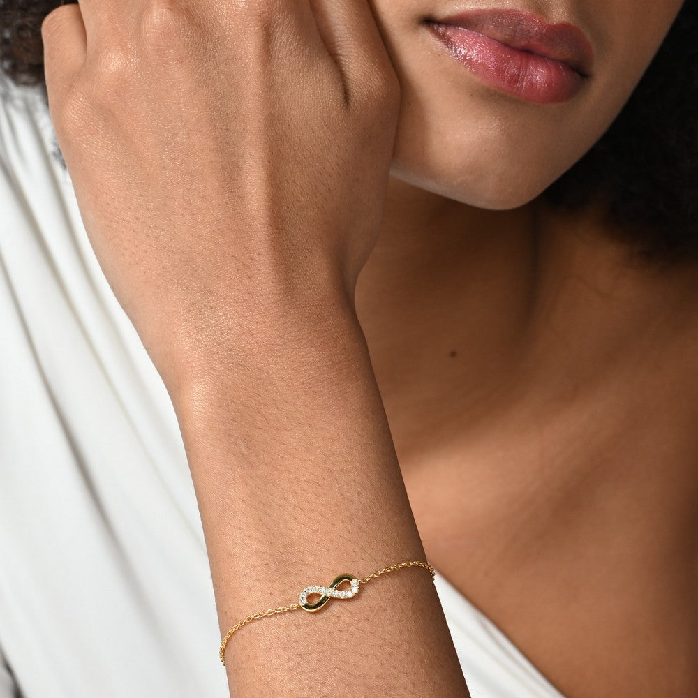 Nahaufnahme von einer vergoldeten Armkette mit einem Infinity Design besetzt mit 11 runden Labordiamanten im Brillantschliff.