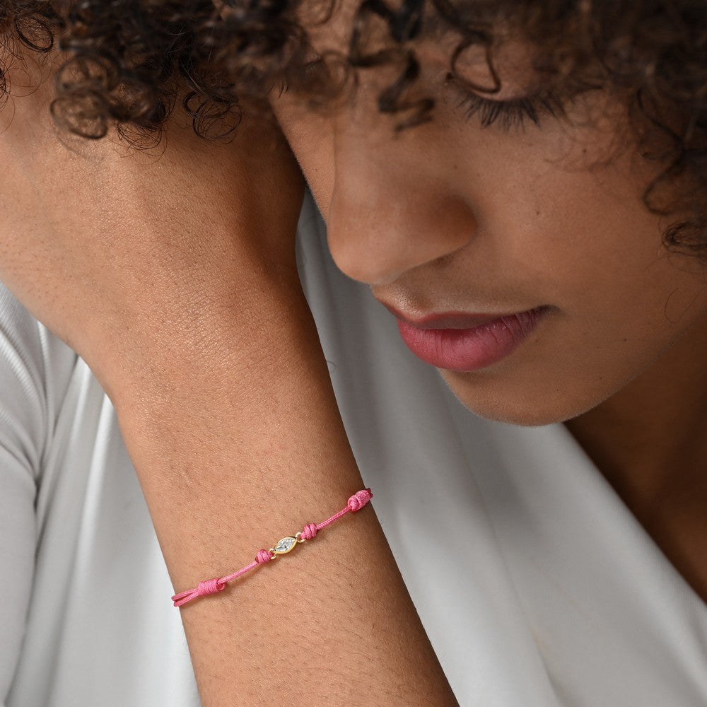 Nahaufnahme von einem pinken Cord-Armband mit einem Labordiamanten im Marquiseschliff am Arm einer Frau getragen.