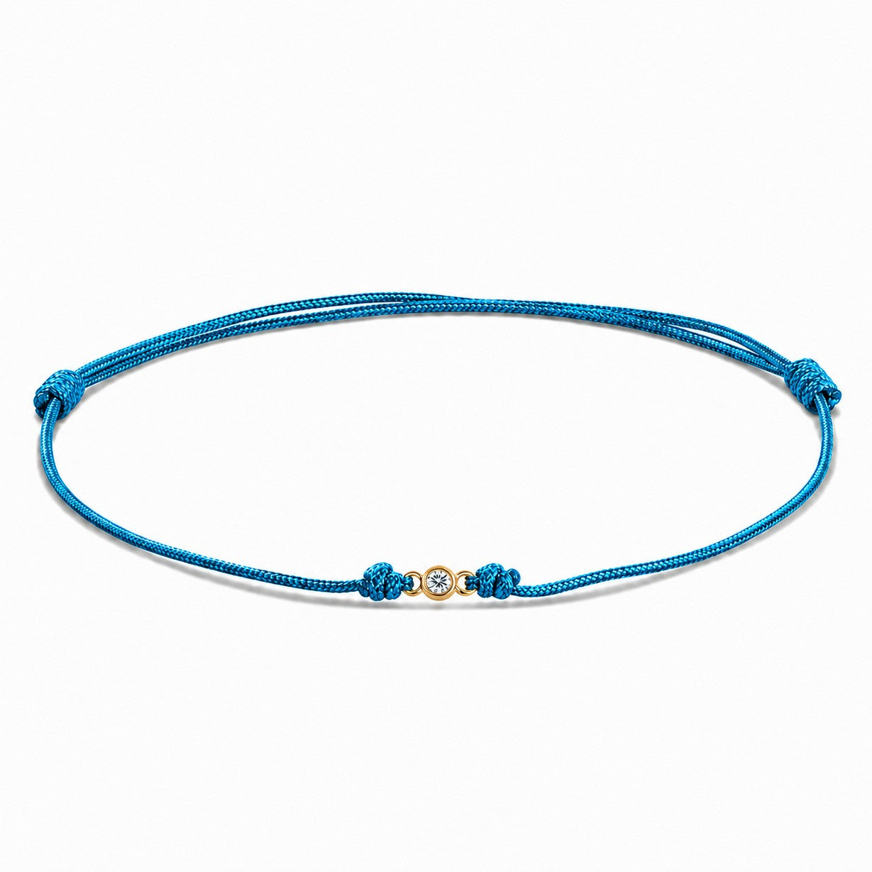 Detailansicht von einem blauen Cord-Armband mit einem kleinen Labordiamanten im Brillantschliff  in Zargenfassung auf weißem Hintergrund.