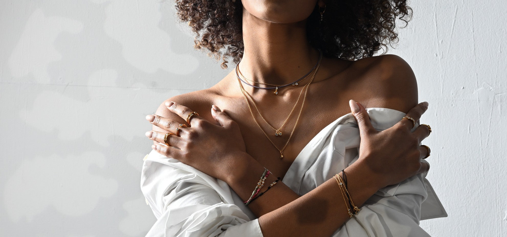 Model präsentiert mehrlagige Lab-Grown-Diamant Halsketten, Ring-Stacks und filigrane Armbänder aus 18 Karat vergoldetem Sterlingsilber.