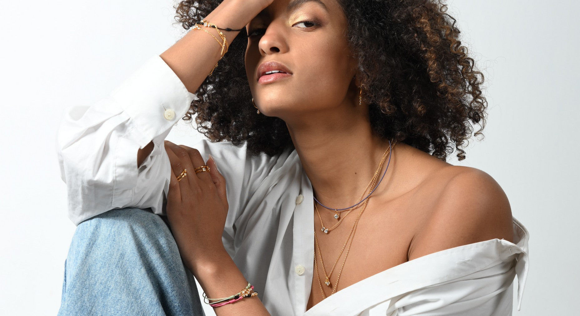 Model trägt mehrlagige Lab-Grown-Diamant Halsketten, Ringe, Ohrringe und Armbänder aus 18 Karat vergoldetem Sterlingsilber.