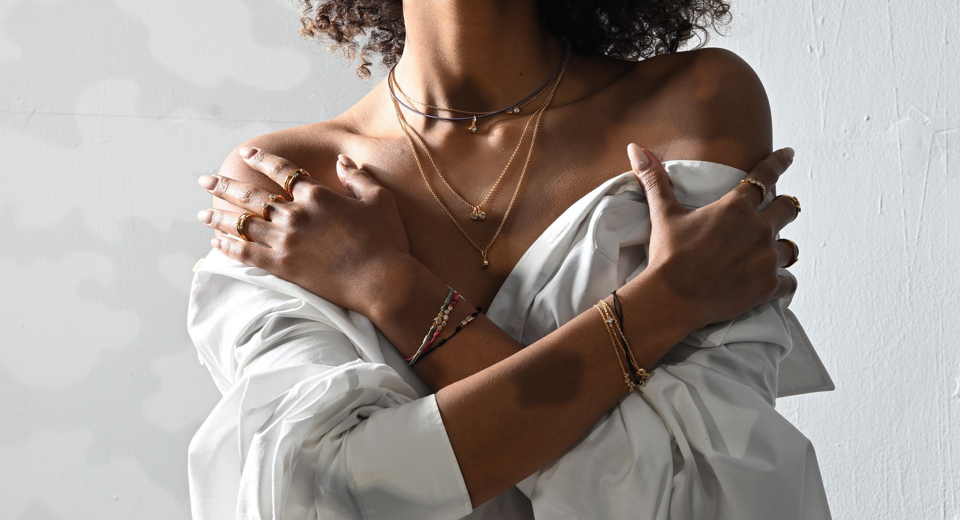 Model trägt Armbänder, Ringe und Halsketten mit lab-grown Diamanten.