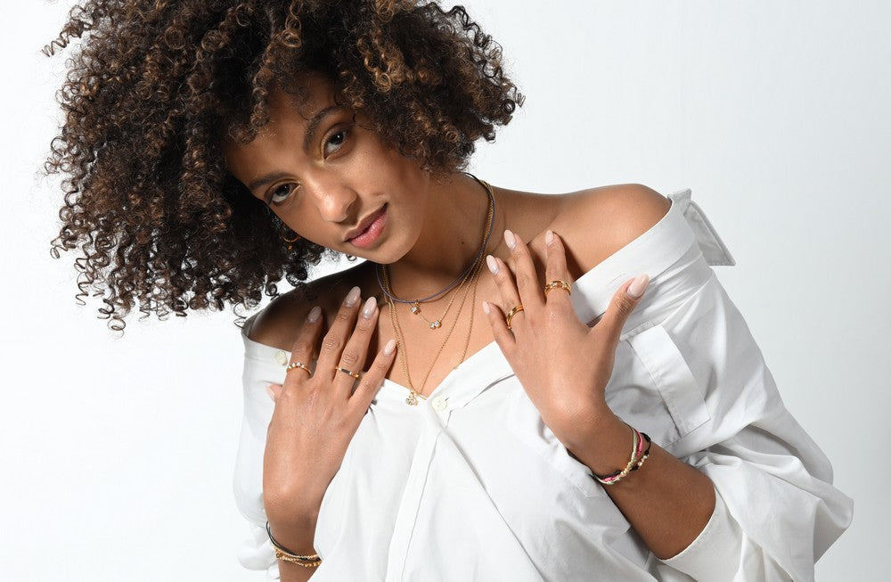 Model trägt ein Stack aus Ringen, Armbändern und Anhängern mit lab-grown Diamanten von amadia-young diamonds.