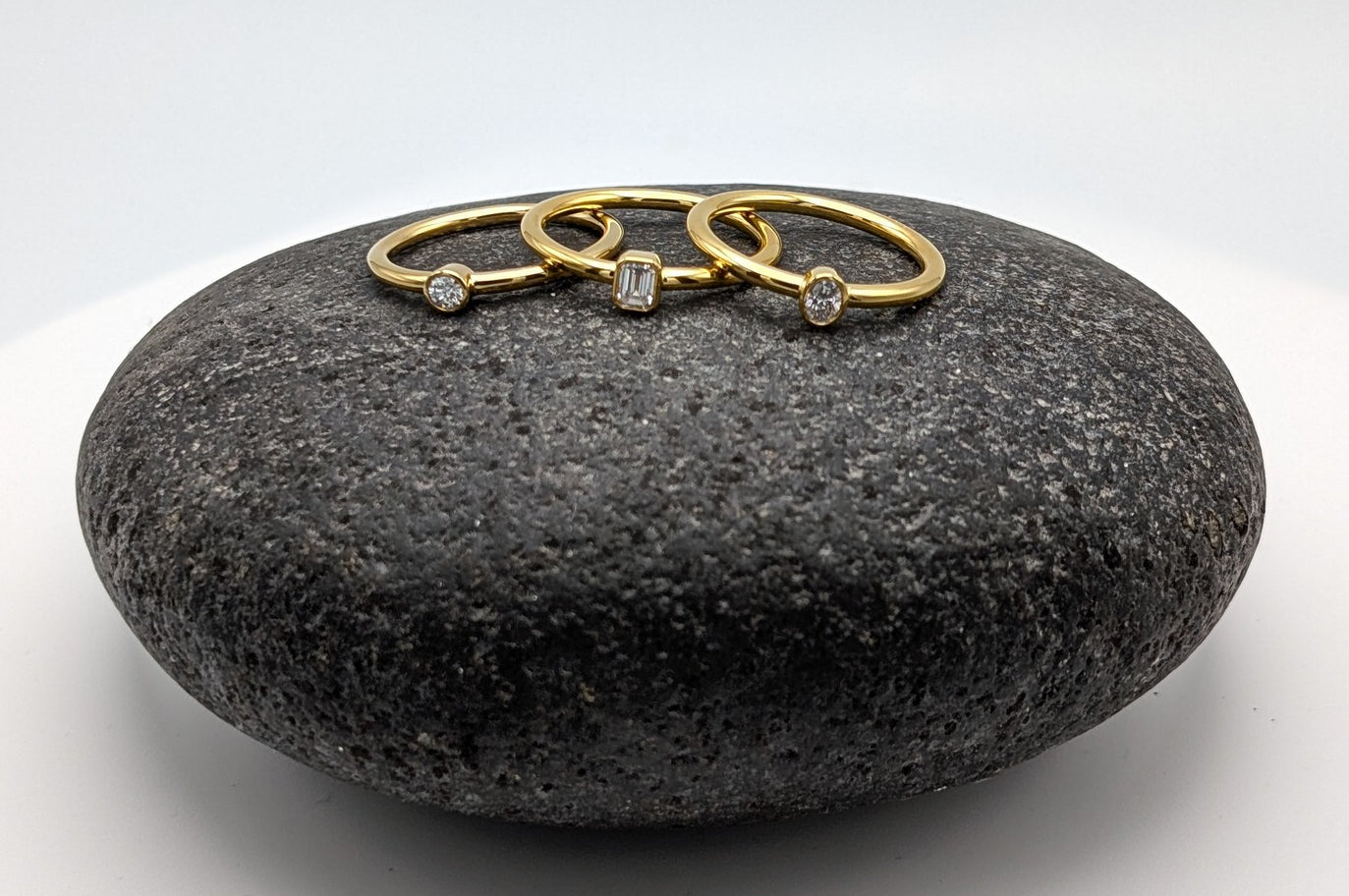 Three golden diamond rings on a big round stone.