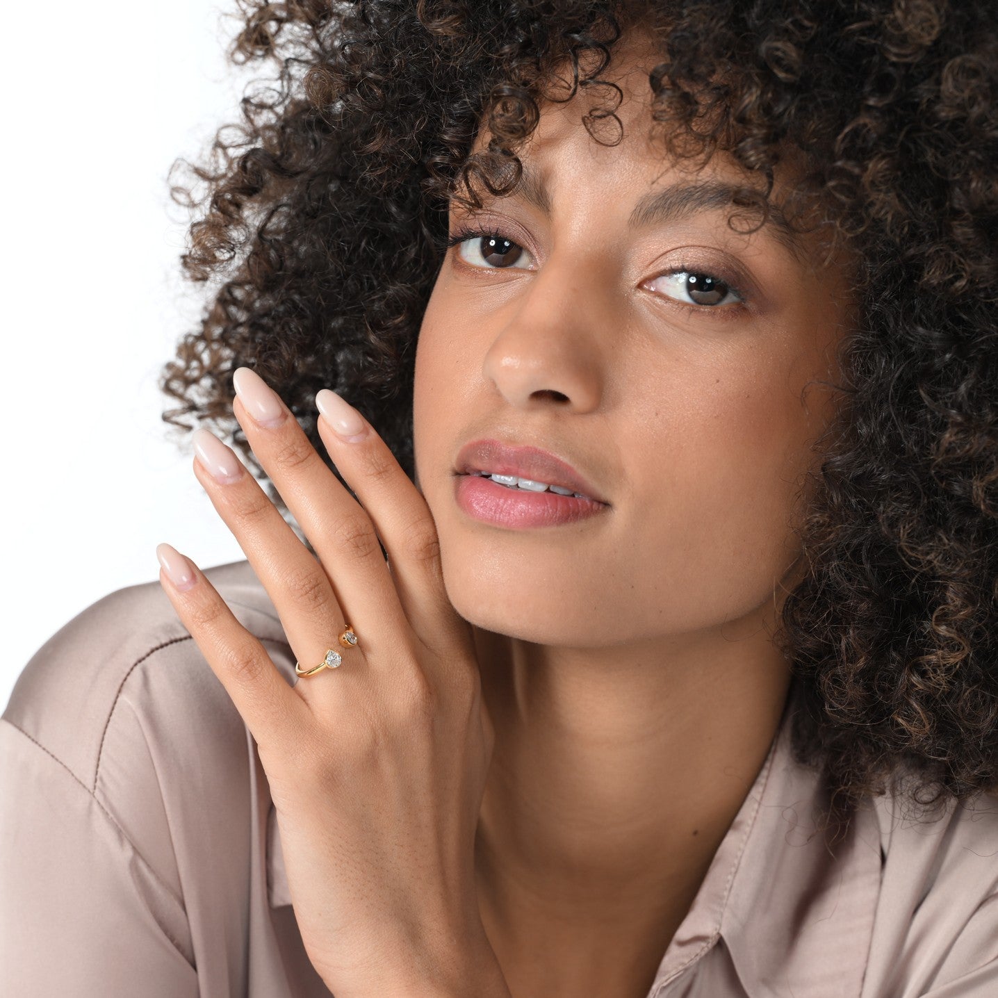 Ein Mädchen mit einem goldfarbenen offenen Ring mit 2 Diamanten am Finger.